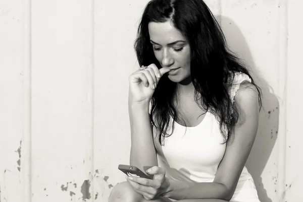 모바일 터치 전화에 메시지를 읽는 젊은 아름 다운 여자 — 스톡 사진