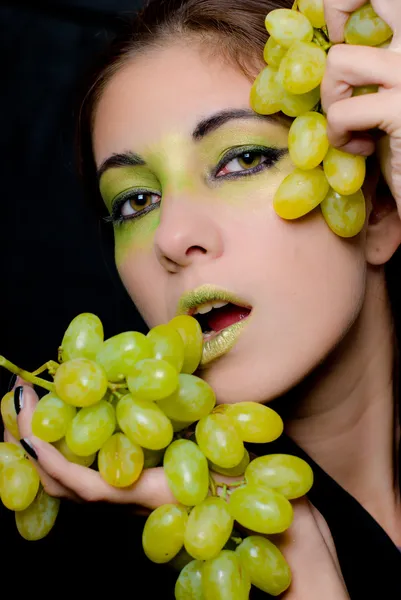 Jeune belle femme tenant des raisins verts gros plan — Photo