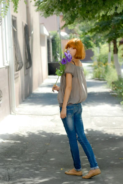 Jolie adolescente rousse avec rose violette par feuilles vertes bac — Photo