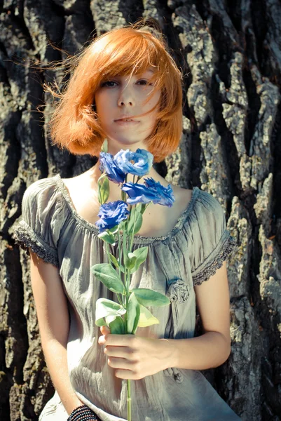 Young beautiful woman smelling purple chinese rose — Stock Photo, Image