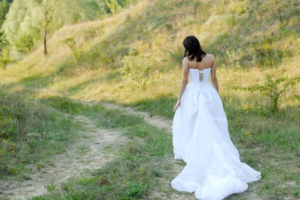 Jeune belle mariée sur le passage de pelouse verte — Photo