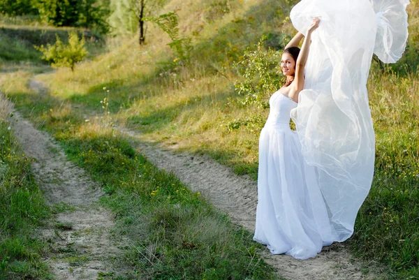 Jovem noiva bonita na passagem gramado verde — Fotografia de Stock
