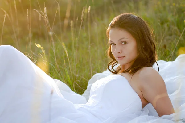 Giovane bella sposa sdraiata in erba verde — Foto Stock