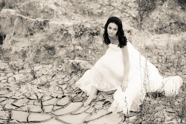 Jovem noiva bonita sentada no deserto — Fotografia de Stock