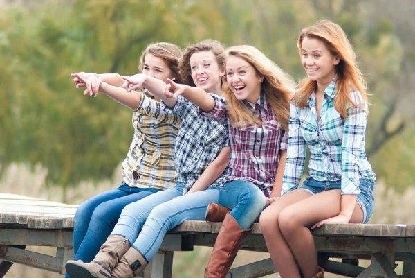 Quatre filles assises sur un pont de rivière — Photo