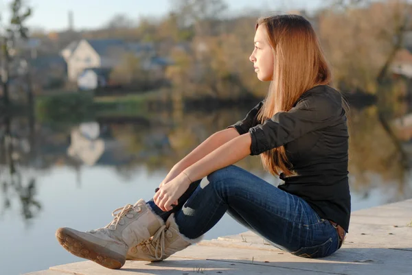 Teenage girl resting on river bank — Stock Photo, Image