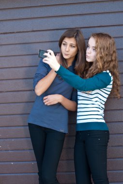 iki genç kızların kendilerini tablet pc kullanarak fotoğraf çekme