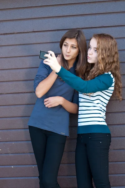 Two teen girls taking picture of themselves using tablet pc — Stock Photo, Image
