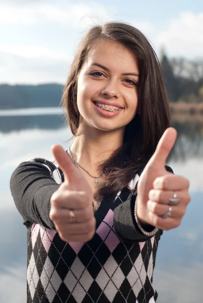 Smiling teenage girl picks up big thumbs up — Stock Photo, Image