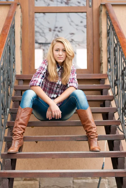 Hübsches lächelndes Teenager-Mädchen sitzt auf der Treppe — Stockfoto
