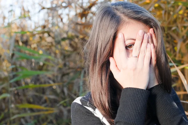 Tienermeisje herfst kleding gezicht met haar handen — Stockfoto