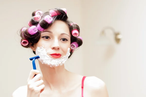 Beautiful funny girl shaving with foam & razor her face — Stock Photo, Image