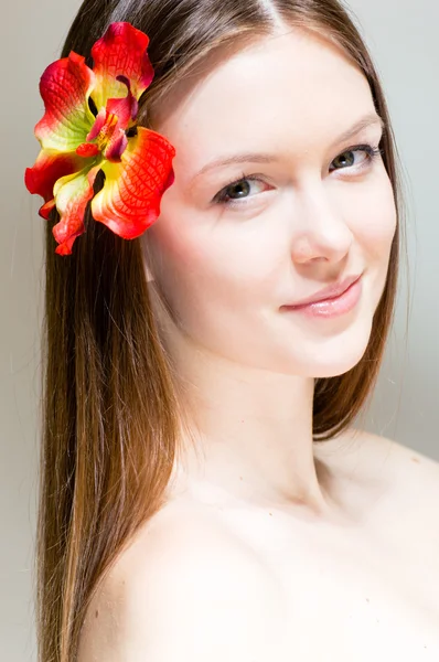 Όμορφη κοπέλα πρόσωπο & λουλούδι. τέλειο δέρμα. — Φωτογραφία Αρχείου