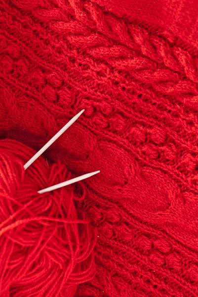 Detail der gewebten Handarbeit stricken wollenen Design Textur und Stricknadel. Stoff roter Hintergrund — Stockfoto