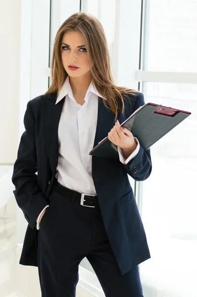 Businesswoman in man's suit & shirt writing with pen at her office fashion styled — Stock Photo, Image