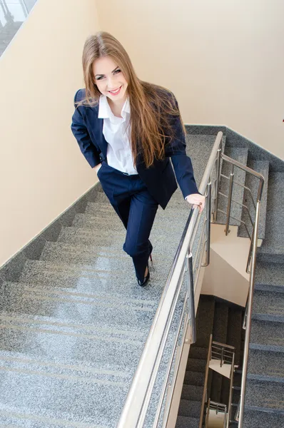 Joven mujer de negocios con traje de hombre caminando por las escaleras — Foto de Stock