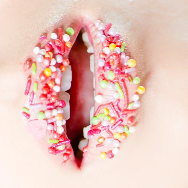 Närbild på kvinnliga söt godis läppar med slickande tunga — Stockfoto