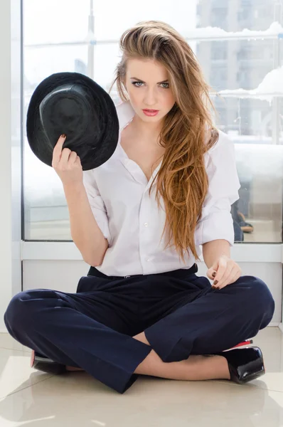 Joven mujer de negocios con camisa de hombre y sombrero en la oficina —  Fotos de Stock