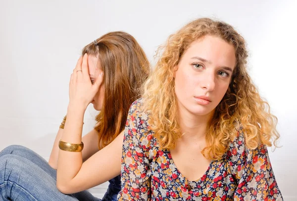 Duas belas mulheres jovens olhando para longe e triste no fundo branco — Fotografia de Stock