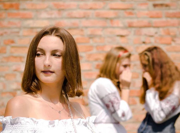 Three young women - teenagers gossiping in summer outdoors — Stock Photo, Image