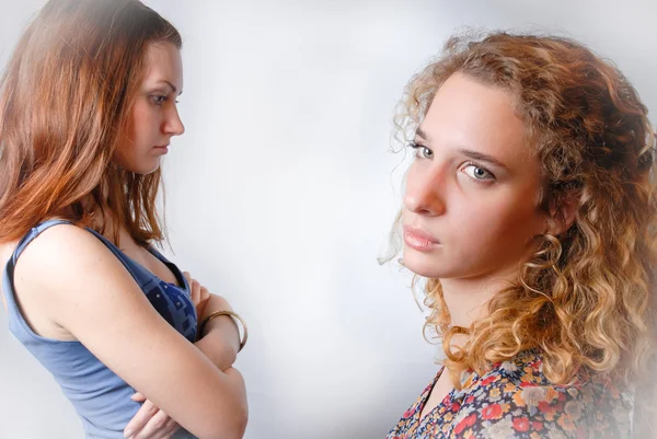 Duas belas mulheres jovens olhando para longe e triste no fundo branco — Fotografia de Stock