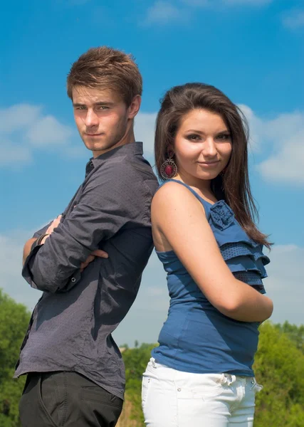 Happy teenage couple embracing over blue sky background — Stock Photo, Image