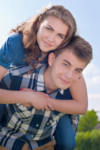 Gelukkige tiener paar omarmen over blauwe hemelachtergrond — Stockfoto