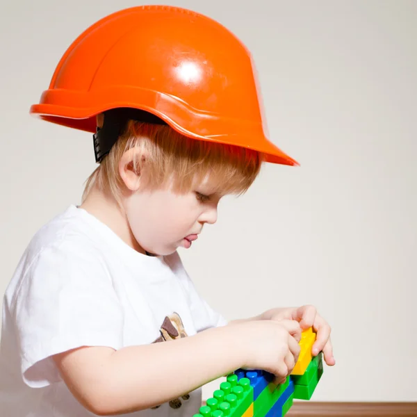 Băiețel în casca constructorului jucându-se cu constructorul — Fotografie, imagine de stoc