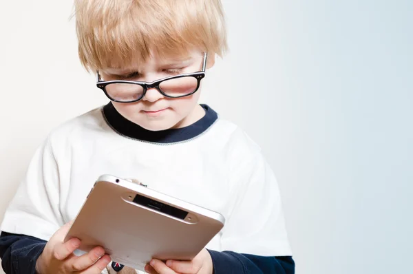 Liten pojke läser på TabletPC — Stockfoto