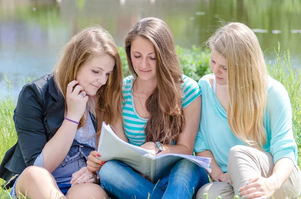 Três adolescente menina amigos leitura livro da escola — Fotografia de Stock