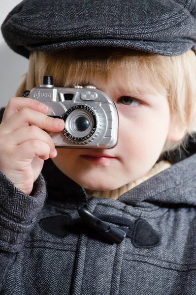 Menino segurando câmera de brinquedo e tirando fotos — Fotografia de Stock