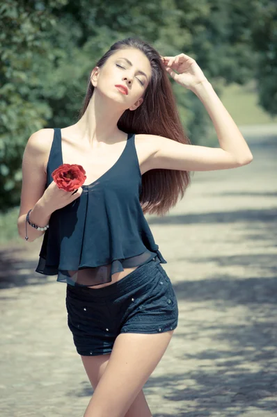Piękna młoda kobieta i czerwona róża — Zdjęcie stockowe