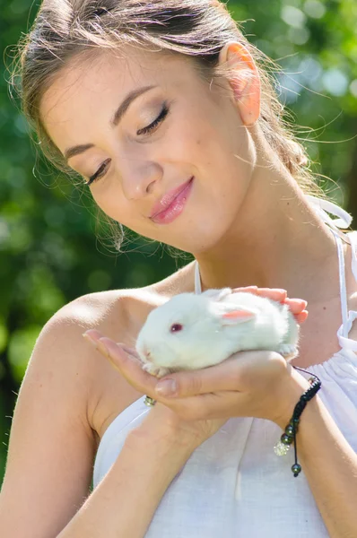 Młoda kobieta szczęśliwa Ogarnięcie mały królik na zewnątrz — Zdjęcie stockowe
