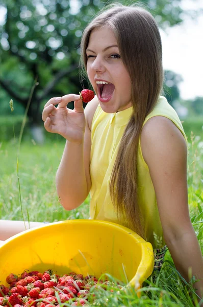 Молодая счастливая девочка-подросток ест клубнику — стоковое фото