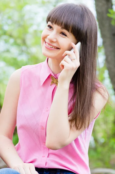 Junge glückliche Frau spricht auf Handy im Freien — Stockfoto