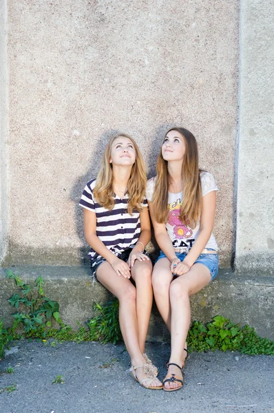 Freundschaft - zwei beste Freundinnen vor grauem Hintergrund — Stockfoto