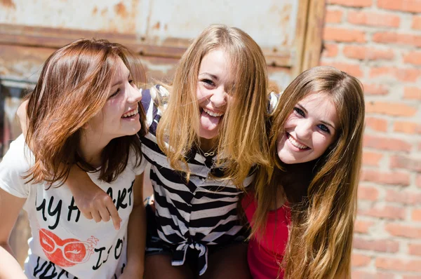 Three young happy teenage girls have fun in city outdoors — Stock Photo, Image