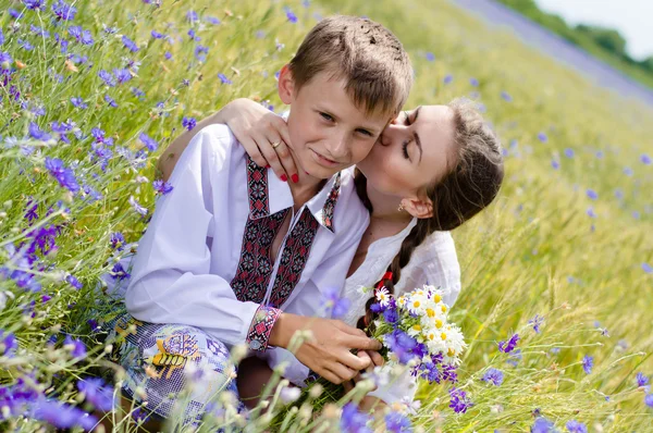 Teenage sister and little brother together on summer wheat fields — Stock Photo, Image