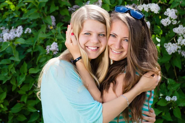 Zwei jugendliche Freundinnen, die im Frühling oder Sommer im Freien lachen — Stockfoto