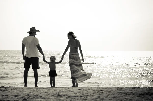 Lycklig familj av tre på sandstranden har roligt — Stockfoto