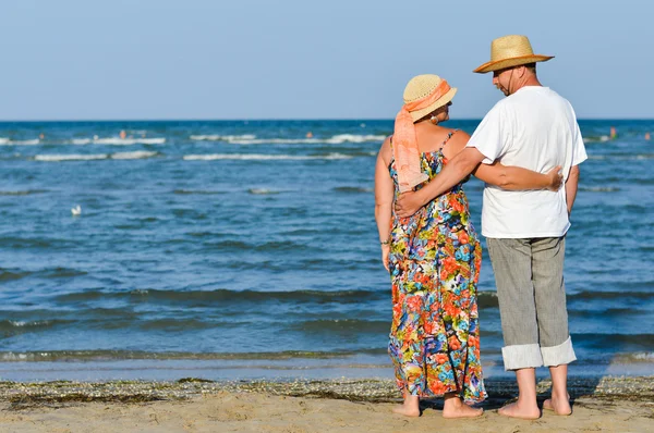 Happy mature couple resting at seashore and embracing — Stock Photo, Image