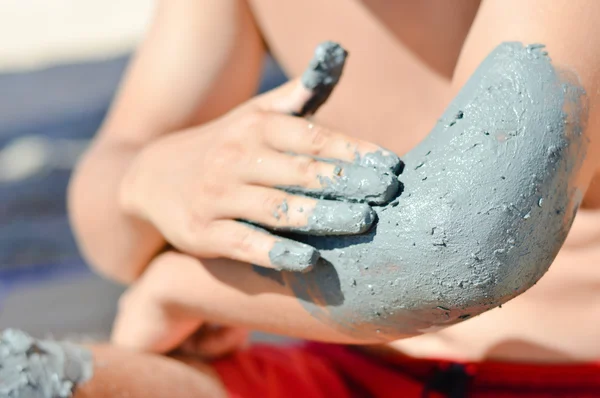 Man applying mineral blue mud on elbow — Stock Photo, Image