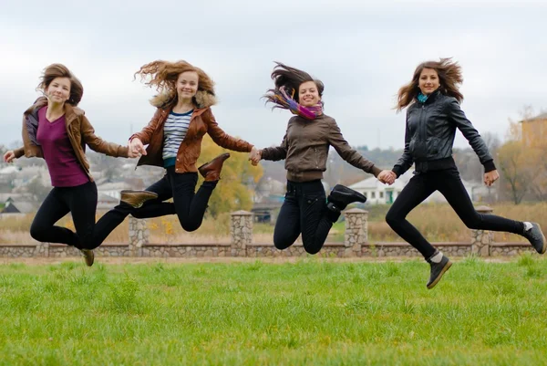 Friends girls jumping high in blue sky — Stock Photo, Image