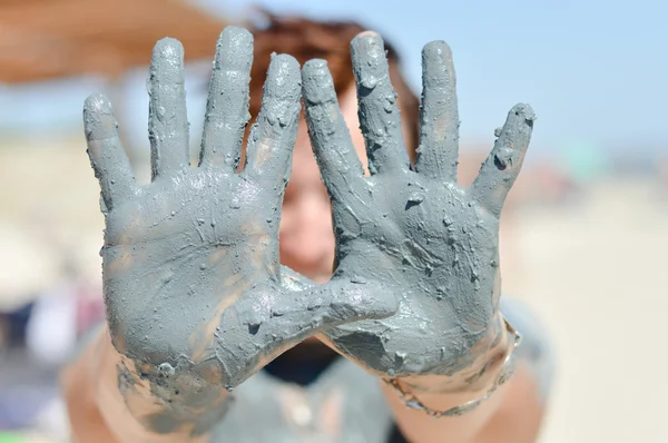 Mujer madura mostrando las palmas fangosas al aire libre — Foto de Stock