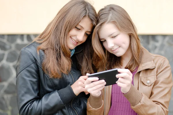 Две девочки-подростка смотрят на планшетный компьютер — стоковое фото