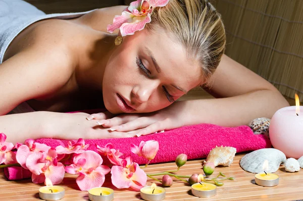 Beautiful woman relaxing during massage with flowers, perfect skin — Stock Photo, Image