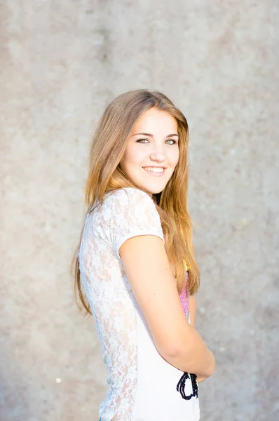 Jeune adolescente heureuse debout au mur gris — Photo