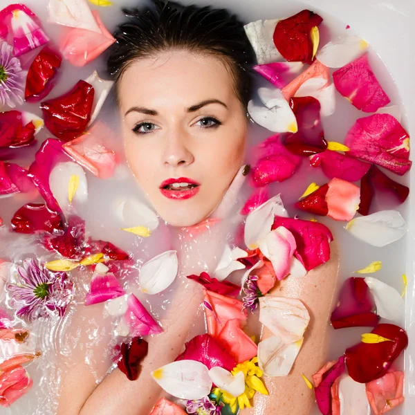 Beautiful sexy young female in bath with flowers and fruit — Stock Photo, Image