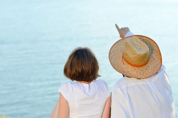 Pareja feliz mirando en copyspace sobre mar azul — Foto de Stock