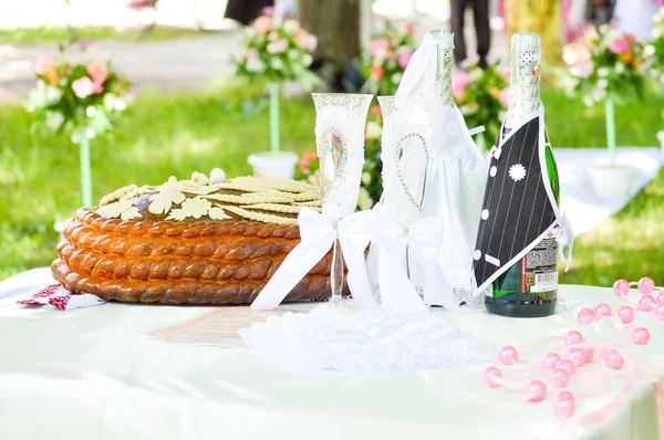 Wedding ceremony details of cake and decorated bottles — Stock Photo, Image